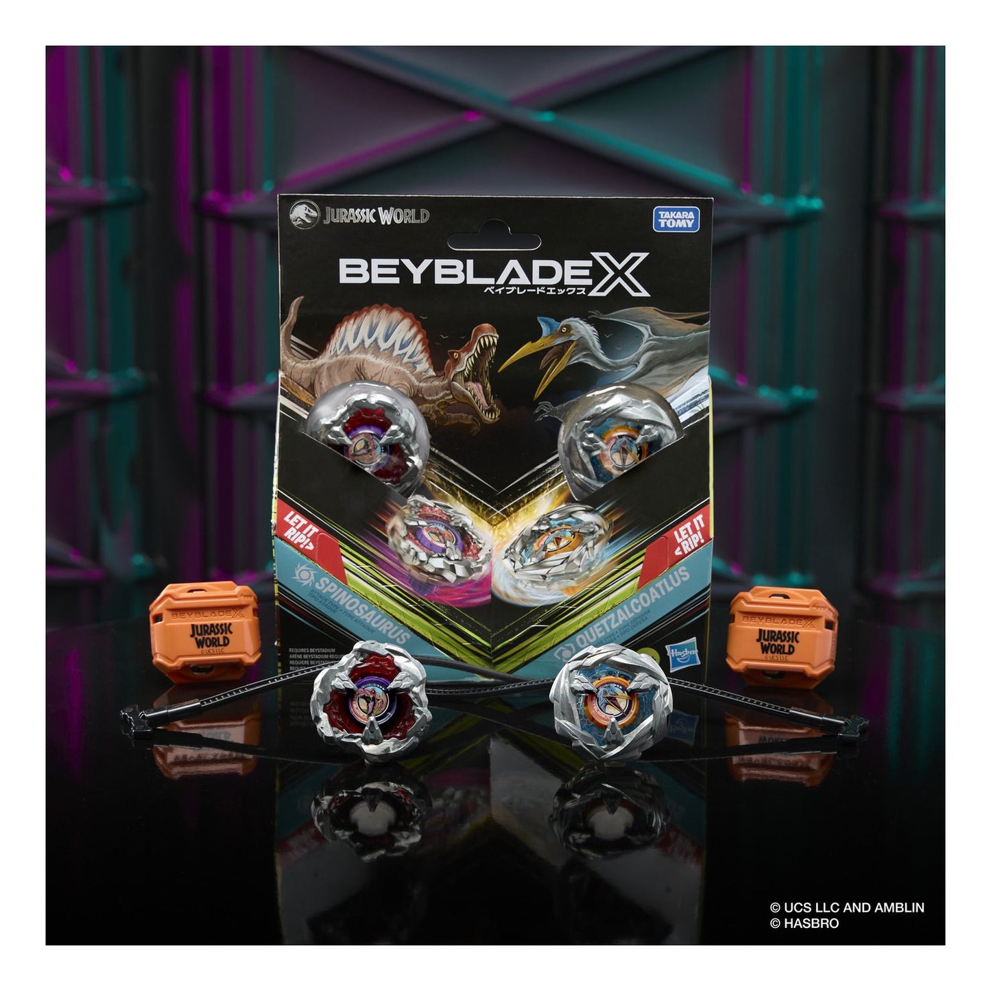 Beyblade packaging with two spinning tops on a reflective surface