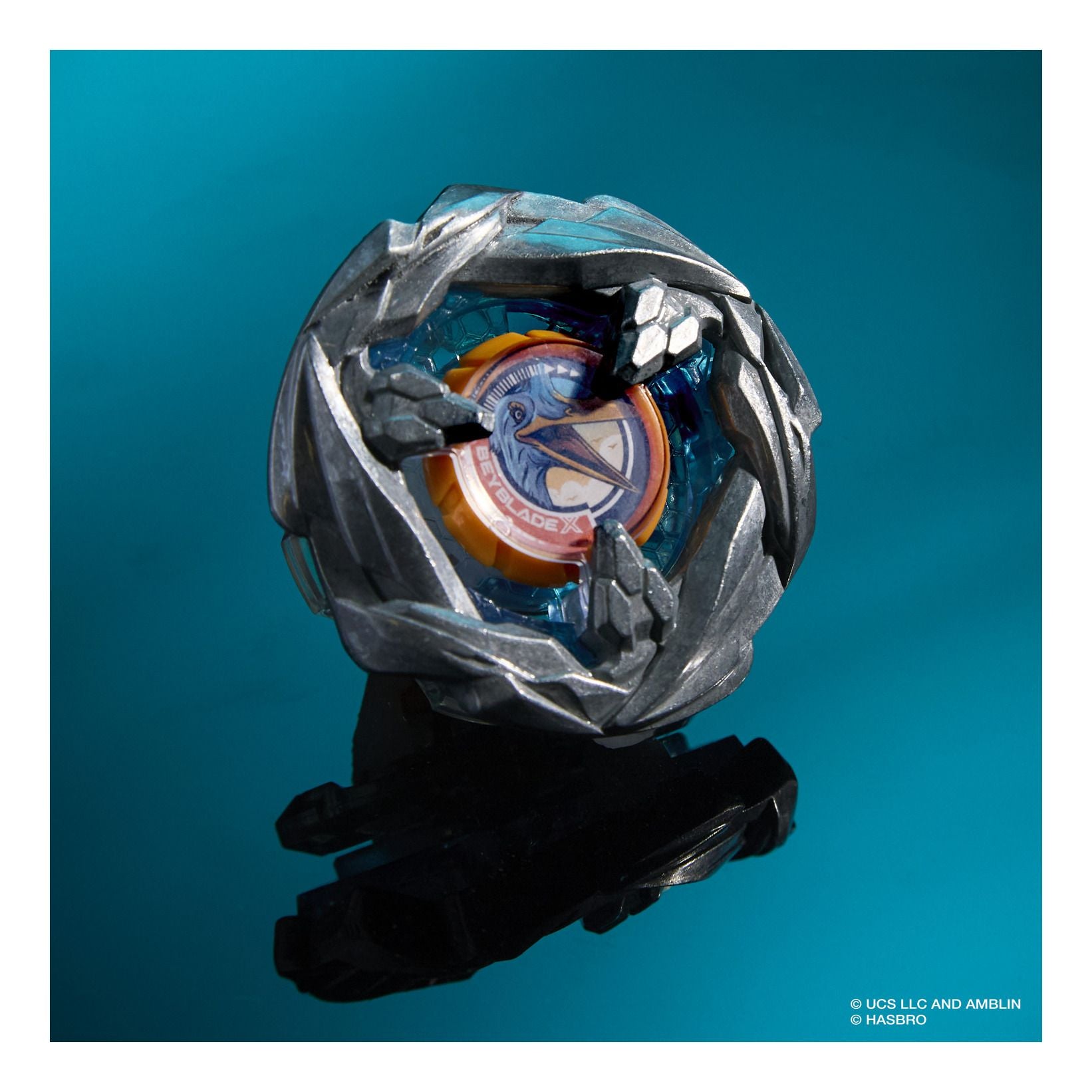 Toy Beyblade on a stand against a blue background
