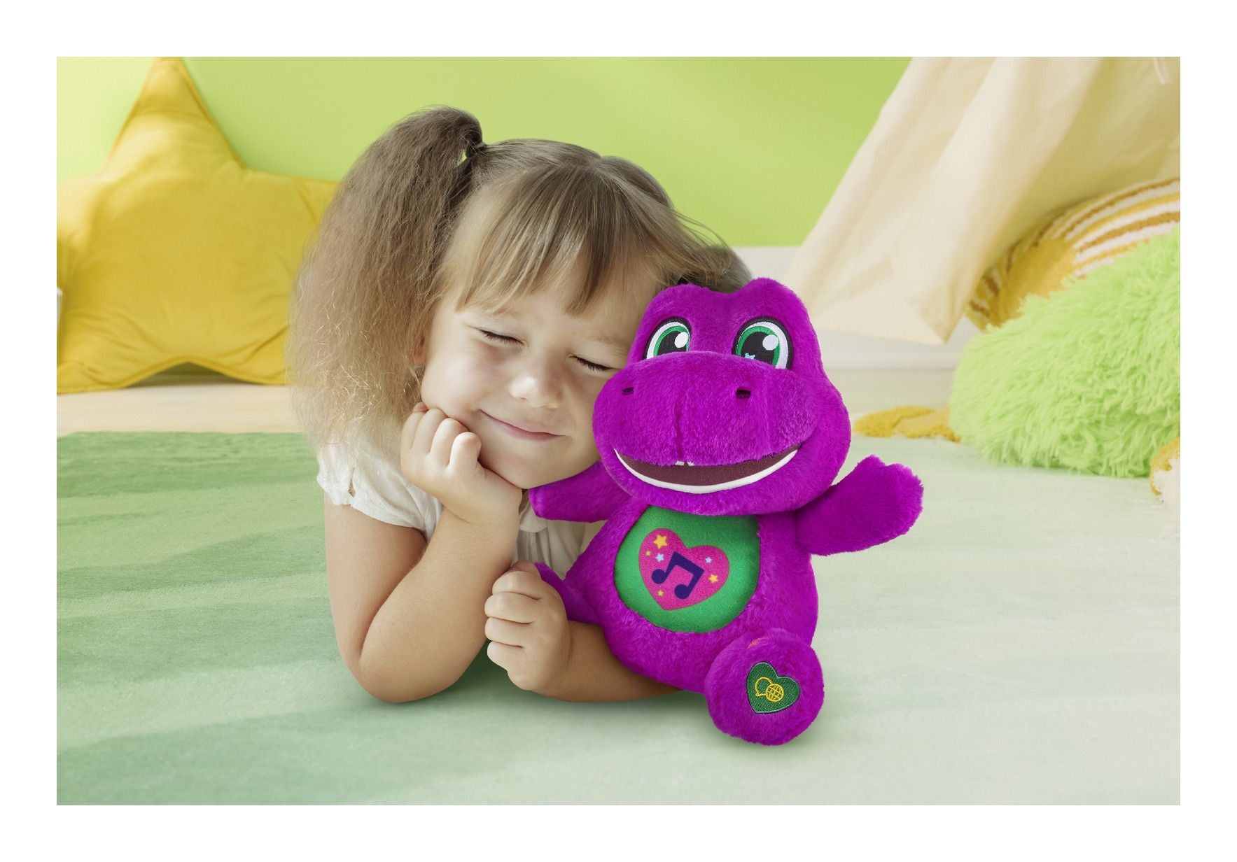 Child holding a purple dinosaur toy with a green background