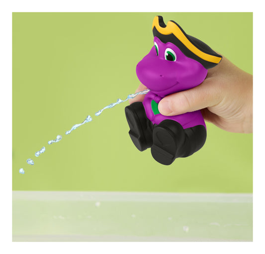 Purple toy dinosaur being held by a hand against a green background