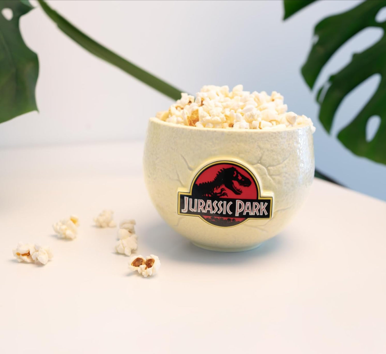 Bowl of popcorn with a Jurassic Park logo on a light background