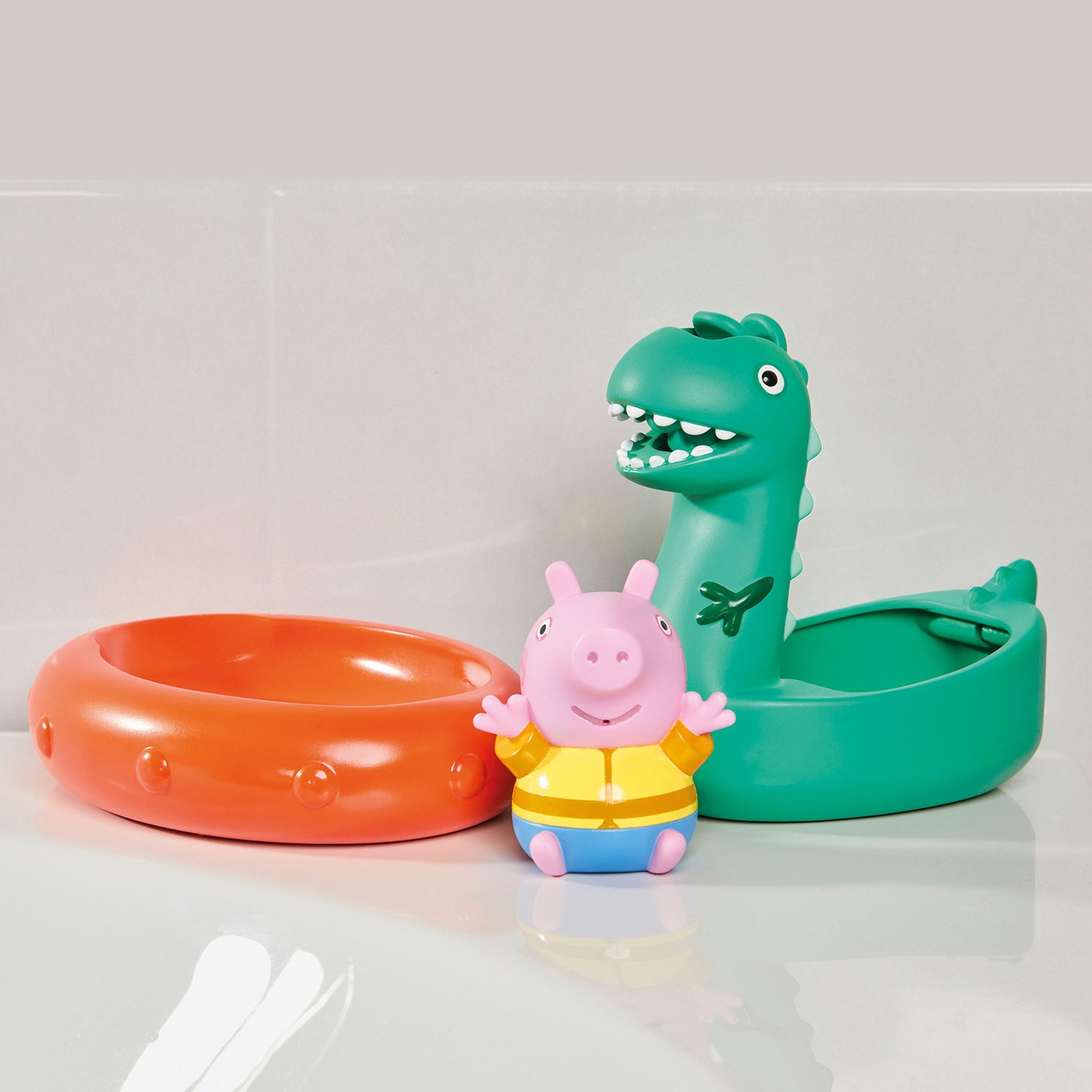 Colorful inflatable rings and a pink character toy on a light gray background