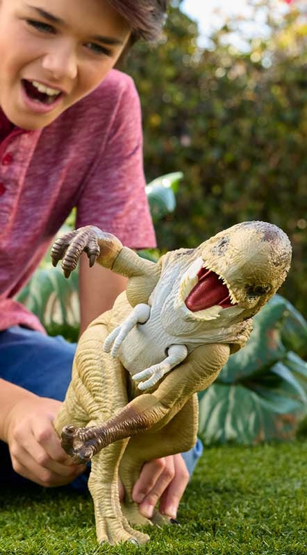 Child playing with a toy dinosaur on grass