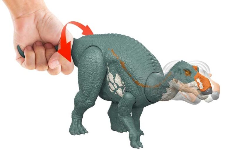 Toy dinosaur with a red handle being held by a hand on a white background