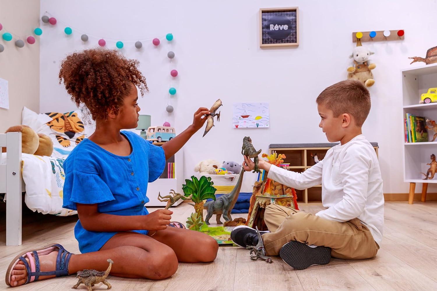 Two children playing with toy dinosaurs in a room with educational posters and toys.