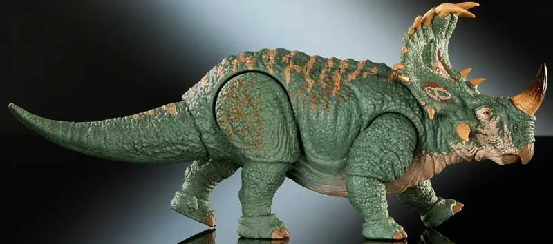 Dinosaur toy model with green and brown coloration on a dark background